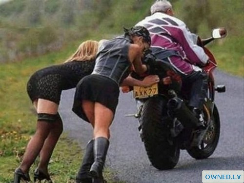 Girls pushing motorbike